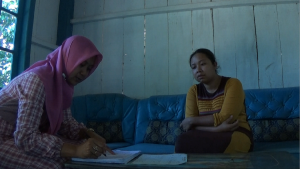 Siti Muntiah sedang melakukan survei kesejahteraan lokal Desa Tracap 